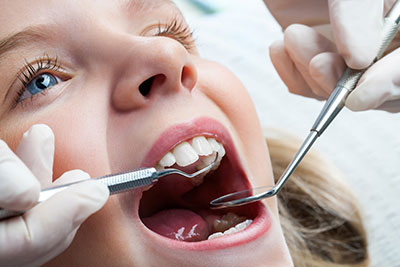 young girl getting her teeth cleaned by a pediatric dentist