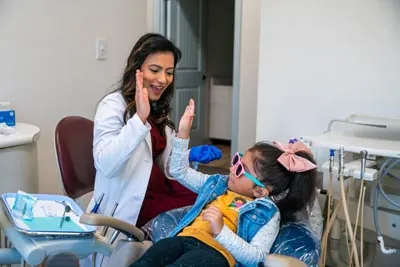 Dr. Pathiyil finishing up pediatric dental care with a patient